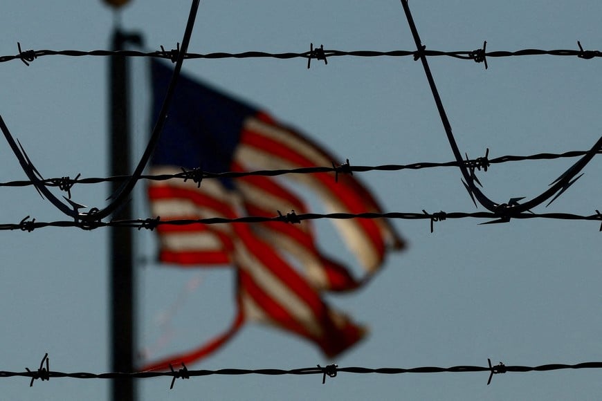 FILE PHOTO: A United States flag is seen near the El Paso airport as Guatemalan migrants, mostly shackled, are being transported to a plane to be expelled from the United States to their country of origin by agents of the U.S. Immigration and Customs Enforcement (ICE) and Border Patrol agents, at the El Paso airport, Texas, U.S., June 13, 2024. REUTERS/Jose Luis Gonzalez/File Photo
