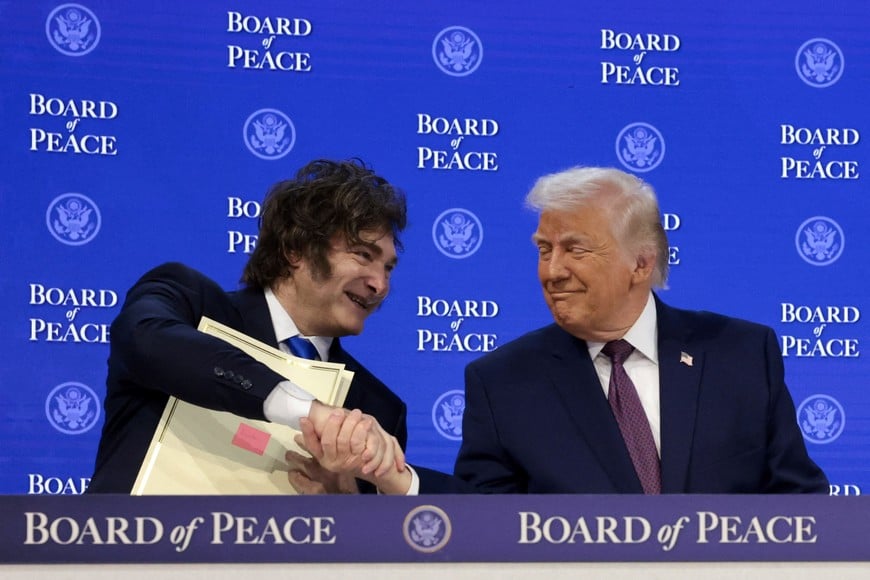 U.S. President Donald Trump shakes hands with Argentina's President Javier Milei as they take part in a charter announcement for Trump's Board of Peace initiative aimed at resolving global conflicts, alongside the 56th annual World Economic Forum (WEF), in Davos, Switzerland, January 22, 2026. REUTERS/Jonathan Ernst