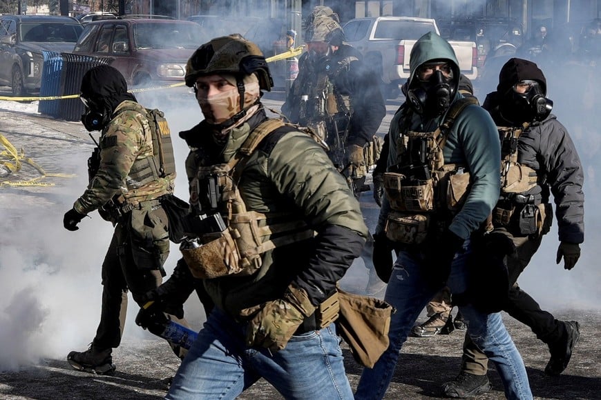 Federal agents amid tear gas at the scene where federal agents fatally shot a man while trying to detain him, in Minneapolis, Minnesota, U.S., January 24, 2026. REUTERS/Tim Evans