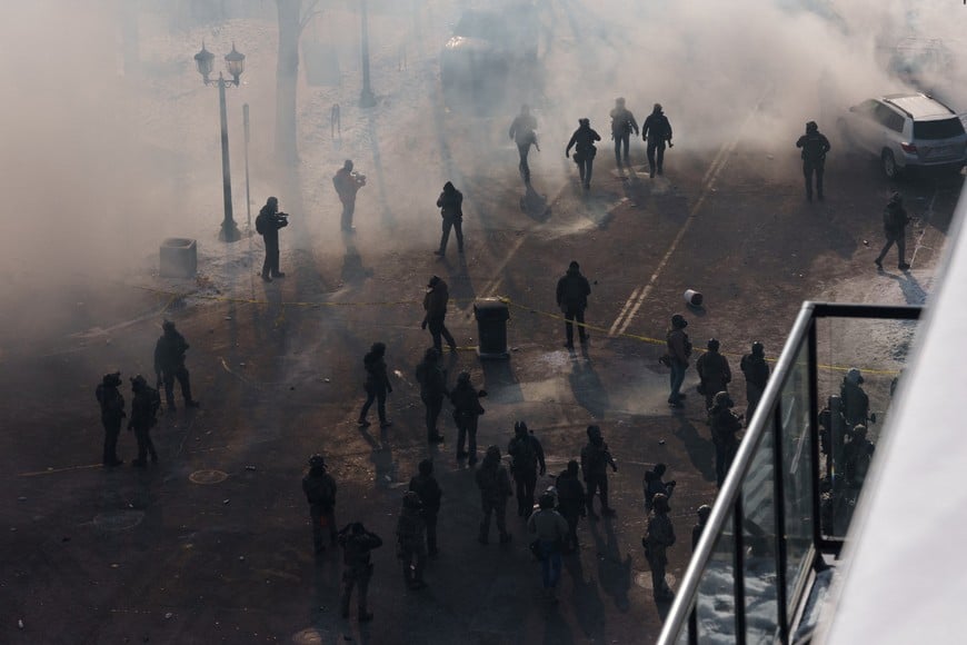 Federal agents walk through a massive cloud of teargas near the site where a man identified as Alex Pretti was fatally shot by federal agents trying to detain him, in Minneapolis, Minnesota, U.S., January 24, 2026. REUTERS/Tim Evans