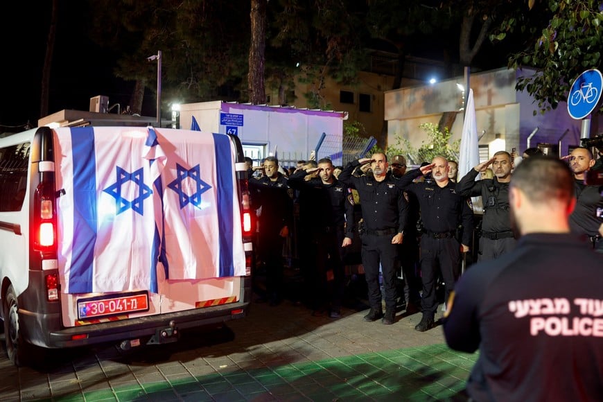 Police officers salute as the vehicle carrying the body of Israeli police officer, and the last hostage Ran Gvili, kidnapped in the October 7, 2023, Hamas attack, arrives to the Institute of Forensic Medicine after being found and identified in the Gaza Strip, according to the statement by the Israeli military, in Tel Aviv, Israel, January 26, 2026. REUTERS/Amir Cohen