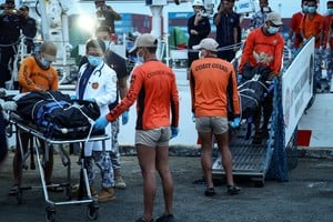 Philippine Coast Guard personnel carry body bags containing the remains of the crew members who died in the sinking of the cargo ship M/V Devon Bay, at the Port of Manila, Philippines, January 26, 2026. REUTERS/Eloisa Lopez