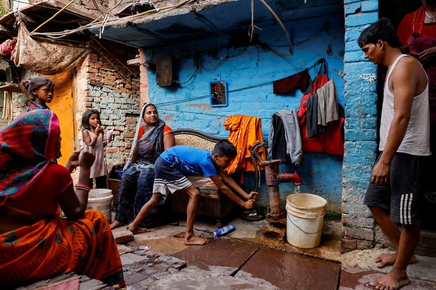 A boy fills water in a container using a hand pump on a hot summer day during a heatwave in New Delhi, India, June 3, 2024. REUTERS/Anushree Fadnavis     TPX IMAGES OF THE DAY