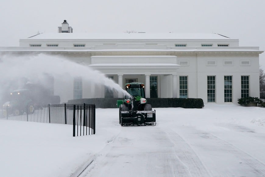A worker clears snow from a White House driveway as a major winter storm spreads across a large swath of the United States, in Washington, D.C., U.S., January 25, 2026. REUTERS/Elizabeth Frantz