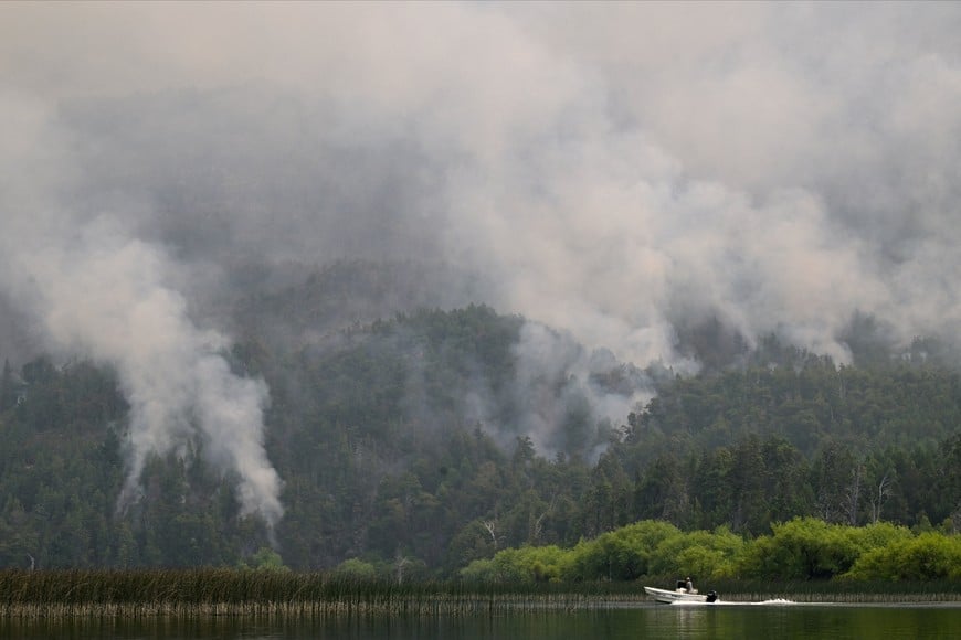 A boat moves across the Lago Epuyen lake during a wildfire in the Patagonian province of Chubut, Argentina January 7, 2026. REUTERS/Maxi Jonas     TPX IMAGES OF THE DAY