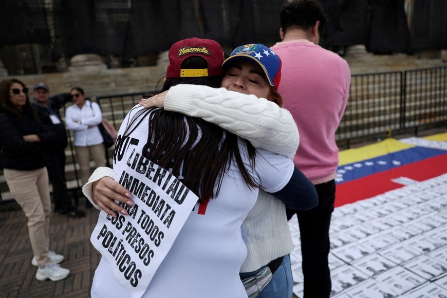 A demonstrator holding a sign that reads "immediate freedom for all political prisoners" hugs another demonstrator, during a gathering at Plaza Bolivar to call for the release of detainees in Venezuela, as the Venezuelan government begins releasing some prisoners following a review process that has drawn attention from human rights groups, international bodies, and opposition leaders, in Bogota, Colombia, January 18, 2026. REUTERS/Luisa Gonzalez