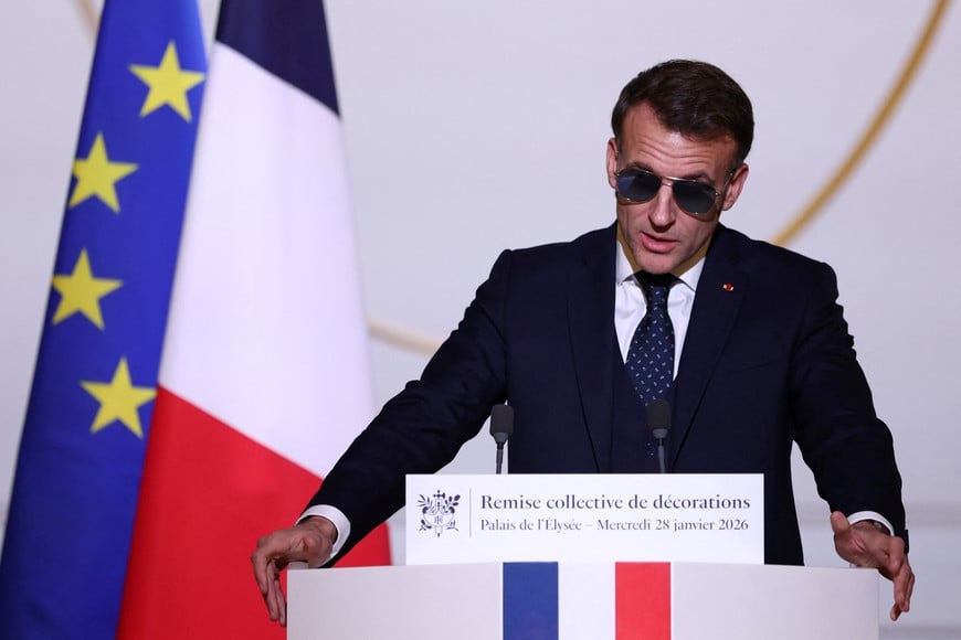 French President Emmanuel Macron, wearing sunglasses, delivers a speech during a ceremony to give the Chevalier of the French Order of Merit award to Ali Akbar, who hawks newspapers around the streets of Saint-Germain-des-Pres in the French capital for 50 years, at the Elysee Palace in Paris, France, January 28, 2026. REUTERS/Tom Nicholson/Pool