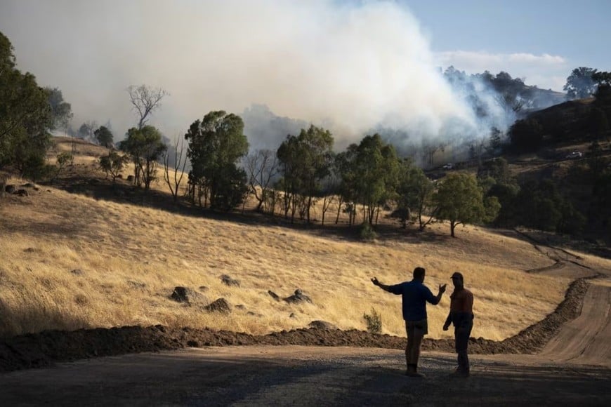 Los agricultores observan un incendio cerca de una propiedad cerca de Euroa, Victoria, Australia, el 10 de enero de 2026. Jay Kogler/SOPA Images/LightRocket/Getty Images