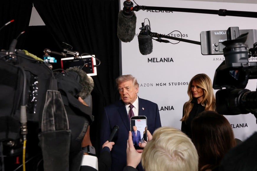 U.S. President Donald Trump and U.S. first lady Melania Trump speak to the media as they arrive for the premiere of the documentary film "Melania" at the John F. Kennedy Center for the Performing Arts, recently renamed to include U.S. President Donald Trump's name, in Washington, D.C., U.S., January 29, 2026. REUTERS/Kylie Cooper