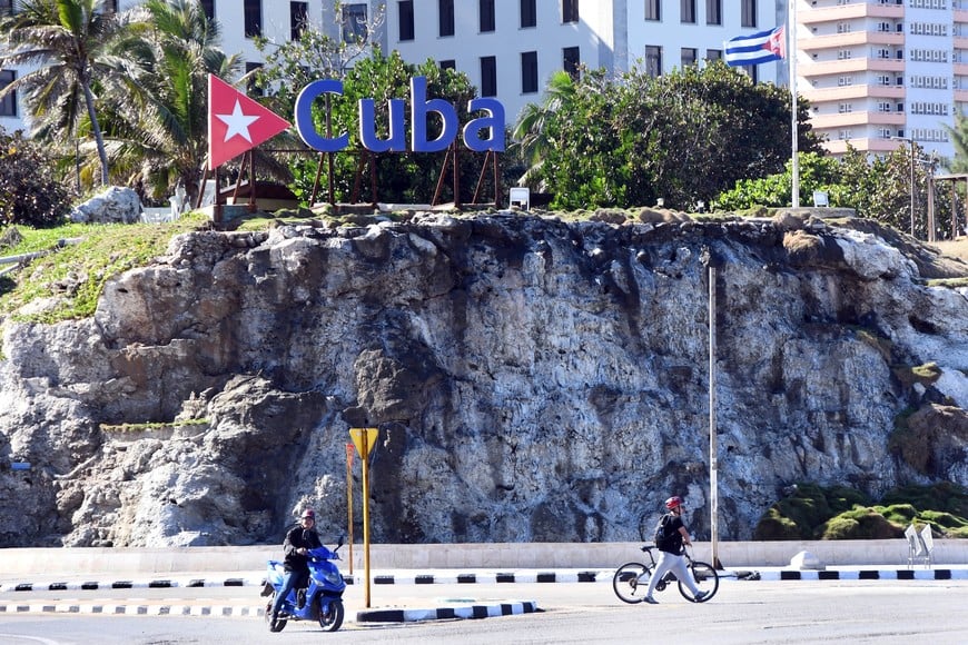 (260105) -- LA HABANA, 5 enero, 2026 (Xinhua) -- Conductores circulan frente a una bandera nacional cubana a media asta, en La Habana, capital de Cuba, el 5 de enero de 2026. El presidente cubano, Miguel Díaz-Canel, decretó el domingo duelo nacional por el fallecimiento de 32 cooperantes militares cubanos en Venezuela, ocurrido durante los ataques perpetrados por Estados Unidos el 3 de enero. (Xinhua/Joaquín Hernández) (jh) (oa) (ah) (vf)