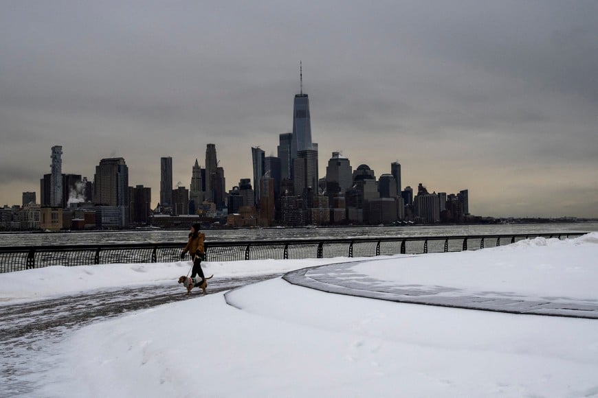 The One World Trade Center and lower Manhattan in New York are seen whilea woman walks her dog, as a major winter storm spreads across a large swath of the United States, as seen from Hoboken, New Jersey, U.S., January 26, 2026. REUTERS/Eduardo Munoz     TPX IMAGES OF THE DAY
