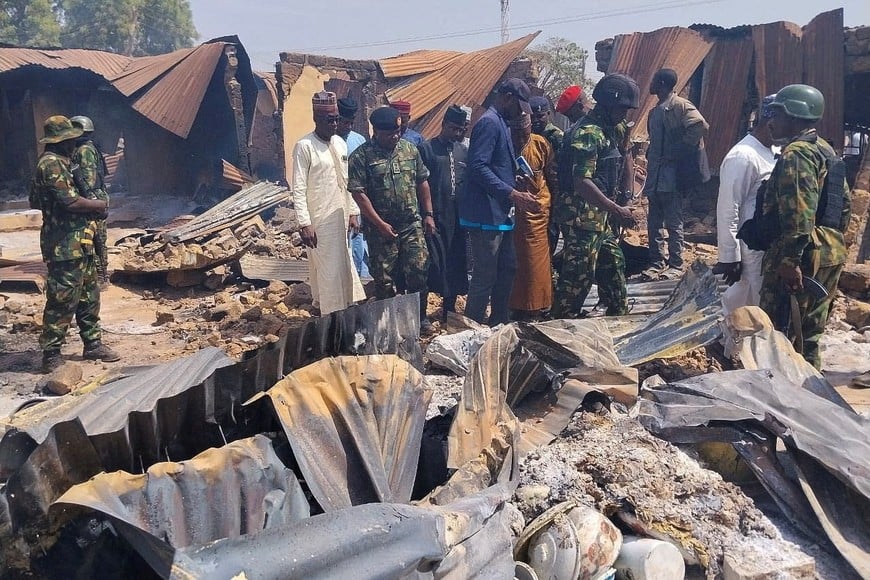 People look on as Nigerian Military arrives at Woro community, after an overnight attack by gunmen that killed dozens of residents, in Kaiama Local Government Area of Kwara State, Nigeria, February 4, 2026.  Picture taken with a mobile phone. REUTERS/Oluseyi Dasilva     TPX IMAGES OF THE DAY