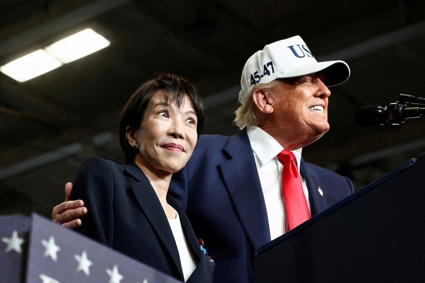 FILE PHOTO: Japanese Prime Minister Sanae Takaichi reacts as U.S. President Donald Trump speaks, aboard the aircraft carrier USS George Washington, during a visit to U.S. Navy's Yokosuka base in Yokosuka, Japan, October 28, 2025. REUTERS/Evelyn Hockstein/File Photo