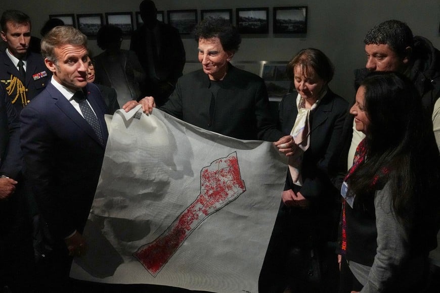 French President Emmanuel Macron, and IMA director Jack Lang, hold a map of Palestine as they visit the exhibition "Treasures rescued from Gaza",  at the Arab World Institute (IMA) in Paris, France April 14, 2025.      Michel Euler/Pool via REUTERS