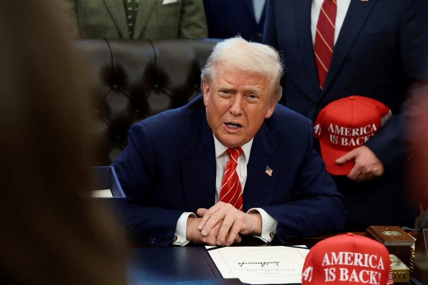 FILE PHOTO: U.S. President Donald Trump sits behind a bill he signed to end the partial government shutdown, at the White House in Washington, D.C., U.S., February 3, 2026. REUTERS/Evelyn Hockstein/File Photo