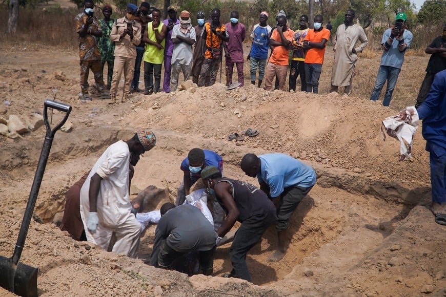 SENSITIVE MATERIAL. THIS IMAGE MAY OFFEND OR DISTURB    People lower the bodies of victims of an overnight attack into a grave at Woro community, where dozens of residents were killed after gunmen stormed the village in Kaiama Local Government Area of Kwara State, Nigeria, February 5, 2026. REUTERS/Ibrahim Ndamitso