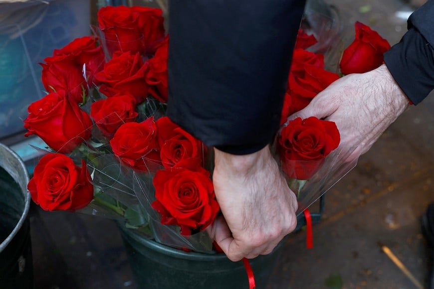 A flower seller prepares red roses for sale at his stall ahead of Valentines Day, in London, Britain, February 13, 2023.  REUTERS/Peter Nicholls