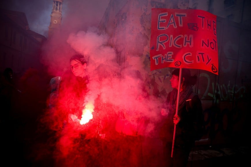 A demonstrator uses a flare during a protest against the environmental, economic and social impact of the Milano-Cortina 2026 Winter Olympics in Milan, Italy, February 7, 2026. REUTERS/Guglielmo Mangiapane