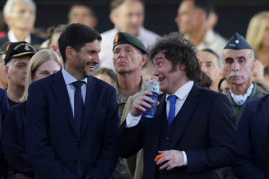 Argentina's President Javier Milei holds a bottle while speaking with Maximiliano Pullaro,  Governor of the Province of Santa Fe, during a ceremony to present the curved sabre that belonged to Argentina's independence leader General Jose de San Martin to the San Lorenzo regiment, in San Lorenzo, Santa Fe, Argentina, February 7, 2026. REUTERS/Francisco Loureiro