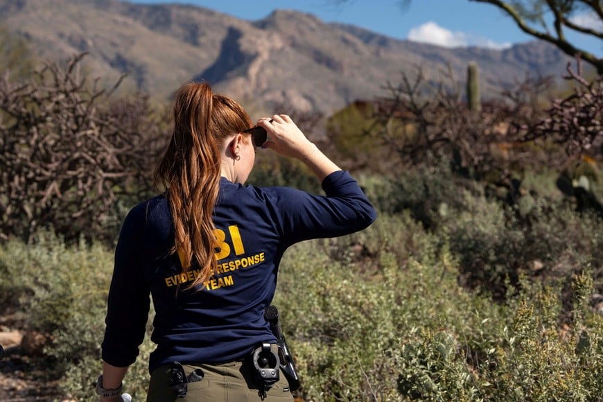 An investigator searches the area near Nancy Guthrie's home in the Catalina Foothills after Guthrie, the 84-year-old mother of U.S. journalist and television host Savannah Guthrie, was reported missing nine days ago, in Tucson, Arizona, U.S. February 11, 2026.  REUTERS/Rebecca Noble
