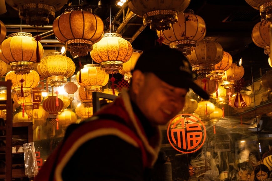 A man reacts at a street food store with lanterns, ahead of Lunar New Year celebrations welcoming the Year of the Fire Horse, in Beijing, China, February 15, 2026. REUTERS/Maxim Shemetov