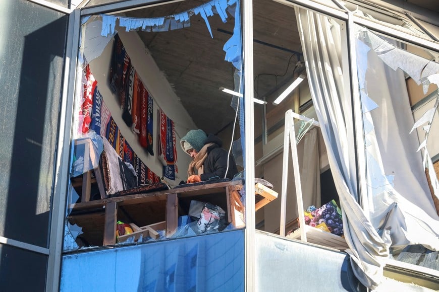 A woman appears in a broken window of a building hit by a Russian drone strike, amid Russia's attack on Ukraine, in Odesa, Ukraine, February 9, 2026. REUTERS/Nina Liashonok     TPX IMAGES OF THE DAY