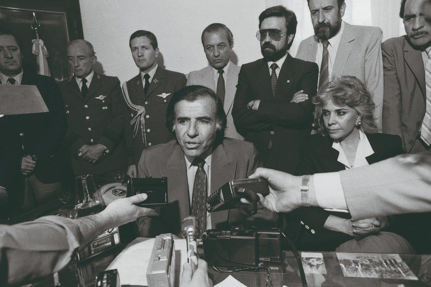 Anuncio de la primera tanda de indultos. Conferencia de prensa en Chamical, provincia de La Rioja, 7 de octubre de 1989. Carlos Menem aparece acompañado por su esposa, Zulema Yoma. Detrás de él, su hermano Eduardo.