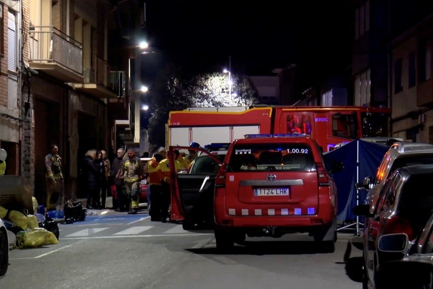 Emergency personnel stand outside an apartment building that caught fire and killed five young people, in Manlleu, in the Catalonia region, Spain, in this screen grab taken from a video obtained on February 17, 2026. FORTA/Handout via REUTERS    THIS IMAGE HAS BEEN SUPPLIED BY A THIRD PARTY.  SPAIN OUT. NO COMMERCIAL OR EDITORIAL SALES IN SPAIN.