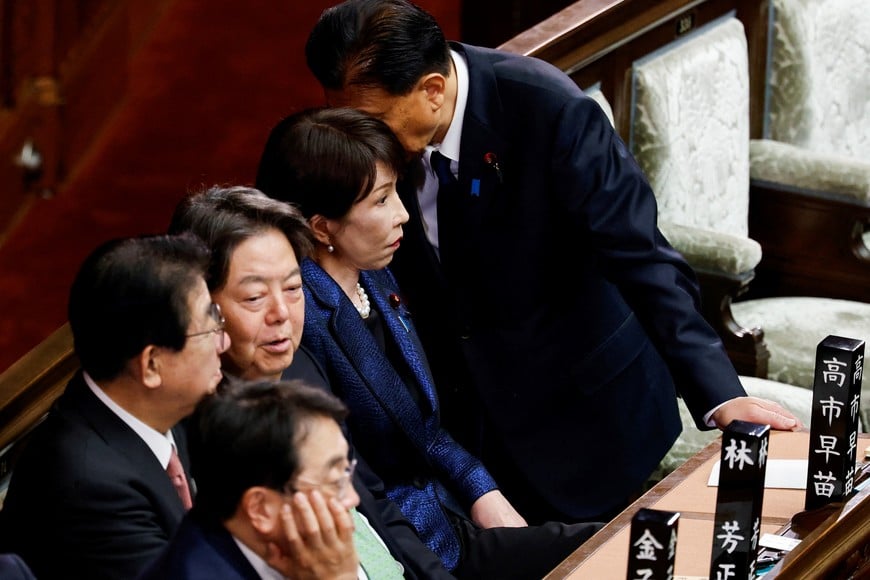 A lawmaker talks to Japanese Prime Minister Sanae Takaichi during a session at the lower house of parliament, on the day lawmakers vote to elect the prime minister after last week's general election, in Tokyo, Japan February 18, 2026. REUTERS/Kim Kyung-Hoon