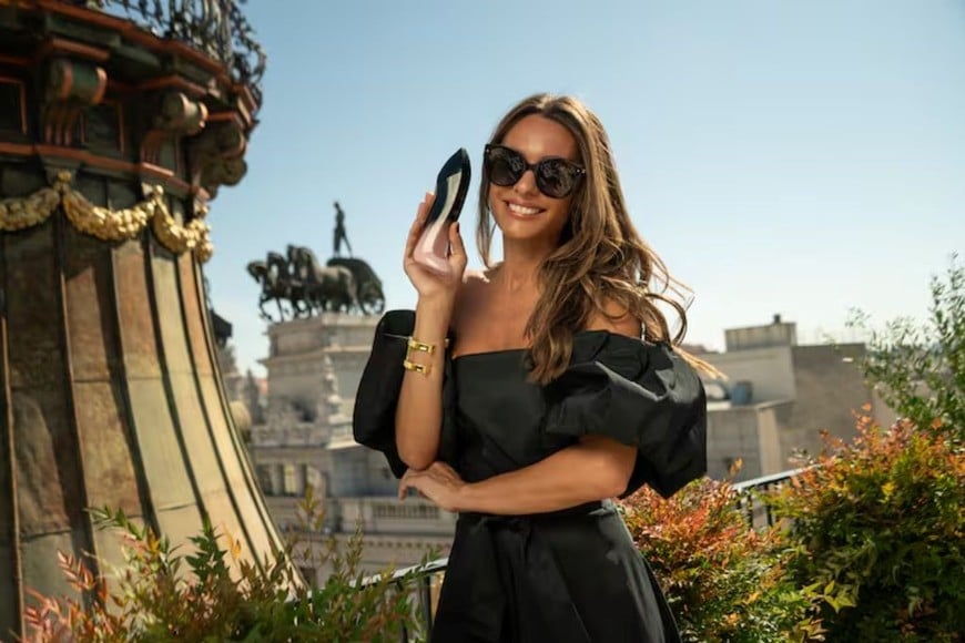 Pampita sosteniendo uno de los icónicos perfumes de Carolina Herrera, Good Girl Blush Elixir.