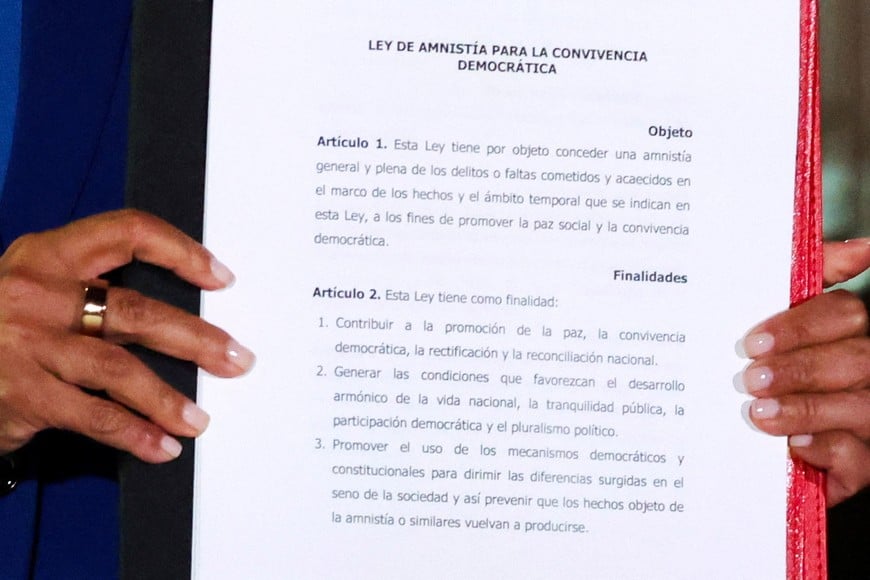 Venezuela's interim President Delcy Rodriguez holds the text of the amnesty law meant to grant immediate clemency to individuals jailed for participating in political protests following its approval, at Miraflores Palace, in Caracas, Venezuela, February 19, 2026. REUTERS/Leonardo Fernandez Viloria
     TPX IMAGES OF THE DAY