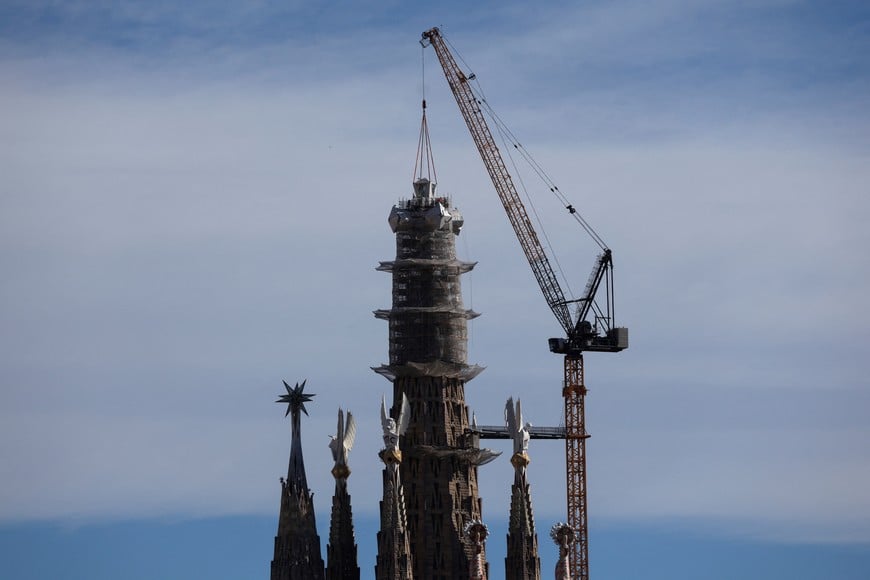 Workers place the upper arm on the cross on the tower of Jesus Christ basilica, which is the tallest piece at Sagrada Familia basilica as part of construction works aimed to be fully finished in this year, in Barcelona, Spain February 20, 2026. REUTERS/Nacho Doce