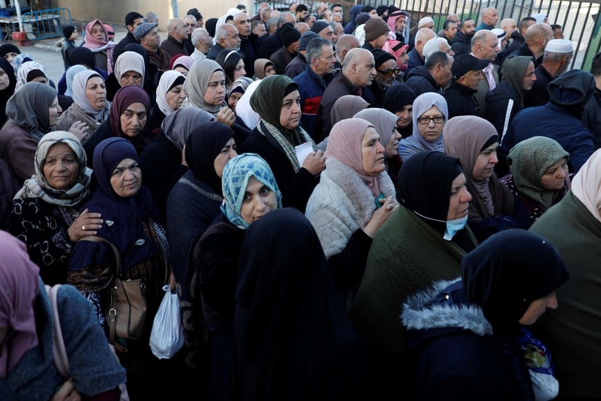 (260220) -- BELEN, 20 febrero, 2026 (Xinhua) -- Palestinos esperan para cruzar un puesto de control israelí mientras se dirigen a la primera oración del viernes del Ramadán en la mezquita de Al-Aqsa de Jerusalén, en la ciudad cisjordana de Belén, el 20 de febrero de 2026. (Xinhua/Mamoun Wazwaz) (oa) (ra) (ce)
