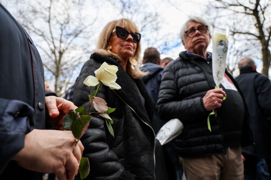 An attendee holds a flower at a march in tribute to Quentin Deranque, a young far-right activist beaten to death during a violent assault by hard-left activists, in Lyon, France, February 21, 2026. REUTERS/Nicolas Economou