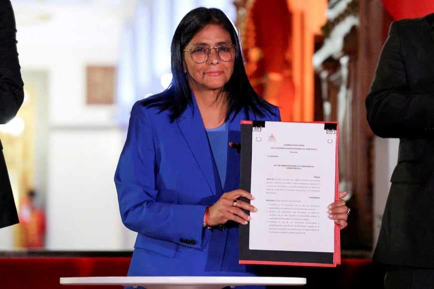 Venezuela's interim President Delcy Rodriguez holds the text of the amnesty law meant to grant immediate clemency to individuals jailed for participating in political protests following its approval, at Miraflores Palace, in Caracas, Venezuela, February 19, 2026. REUTERS/Leonardo Fernandez Viloria   REFILE - QUALITUY REPEAT