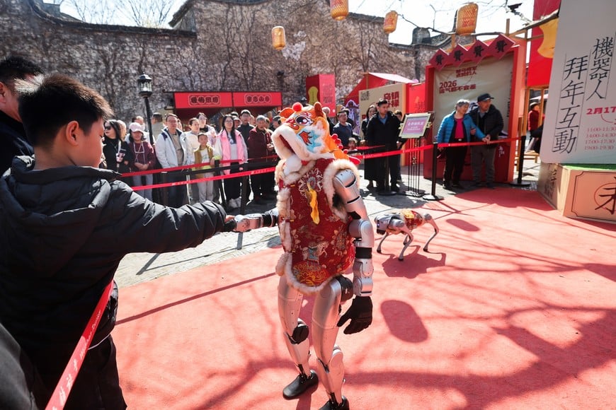 (260221) -- TONGXIANG, 21 febrero, 2026 (Xinhua) -- Un turista estrecha la mano con un robot, en Wuzhen, en la ciudad de Tongxiang, en la provincia de Zhejiang, en el este de China, el 21 de febrero de 2026. Durante estas vacaciones de la Fiesta de Primavera, el antiguo poblado acuático de Wuzhen ha organizado más de sesenta actividades que muestran la rica historia y la vitalidad moderna del poblado, reflejadas en las costumbres populares, el teatro, la ciencia y tecnología, y la cultura. (Xinhua/Xu Yu) (oa) (da)