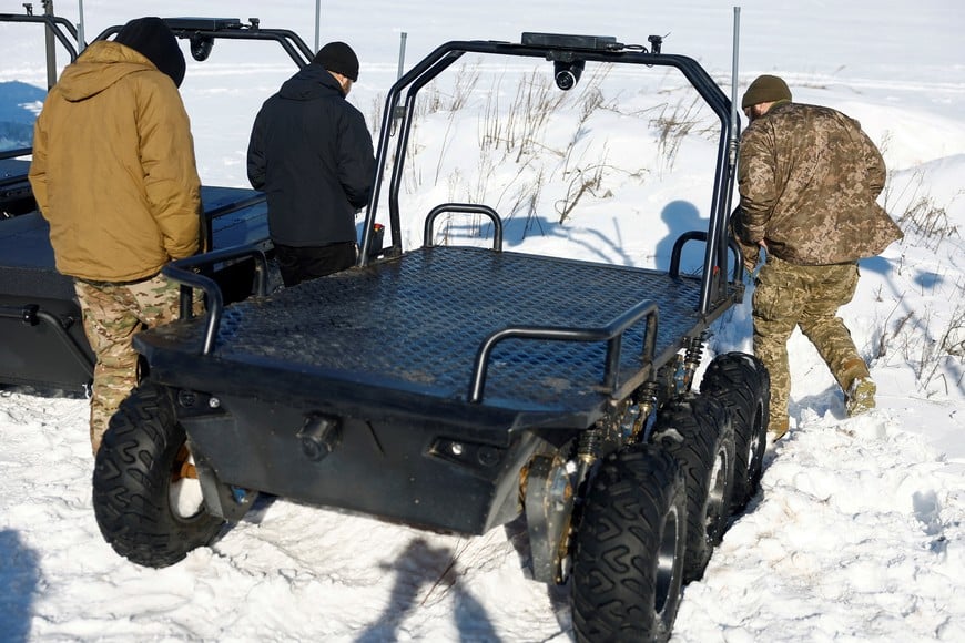 Ukrainian service members look at an unmanned ground vehicle as they visit an exhibition of Ukrainian drone makers, amid Russia's attack on Ukraine, in an undisclosed location, Ukraine February 20, 2026. REUTERS/Valentyn Ogirenko