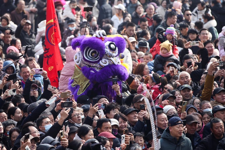 (260221) --BEIJING, 21 febrero, 2026 (Xinhua) -- Personas observan una presentación de danza Yingge, en el distrito de Shuimogou de Urumqi, en la región autónoma uygur de Xinjiang, en el noroeste de China, el 21 de febrero de 2026. Durante las vacaciones de la Fiesta de la Primavera, muchos equipos de danza Yingge han realizado magníficas presentaciones por toda China. La danza Yingge, o "danza a la canción del héroe", es una danza folclórica de la provincia de Guangdong, en el sur de China, que ha gozado de creciente popularidad en todo el país en los últimos años. Como una fusión dinámica de teatro, danza y artes marciales, fue incluida entre el primer grupo del patrimonio cultural inmaterial nacional en 2006. (Xinhua/Li Wenwu) (jg) (da)