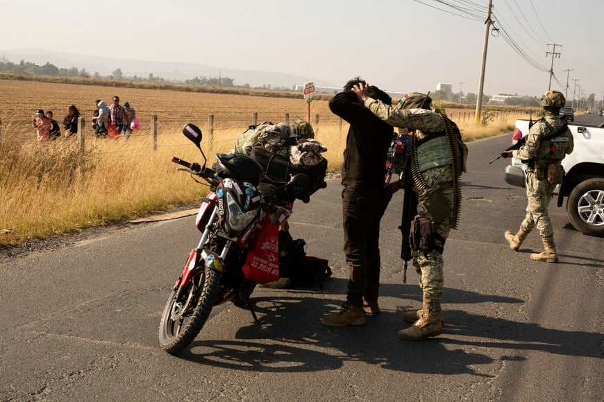 Soldiers check motorcycle drivers after organized crime burned vehicles to block roads following a federal operation in which a government source said Mexican drug lord Nemesio Oseguera, commonly known as "El Mencho," was killed, in Zapopan, Mexico, February 22, 2026. REUTERS/Gabriel Trujillo