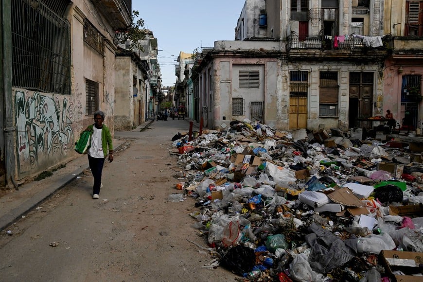 A woman walks next to trash on a street in downtown Havana, Cuba, February 15, 2026. REUTERS/Norlys Perez  REFILE - CORRECTING DATE FROM "FEBRUARY 16" TO "FEBRUARY 15".