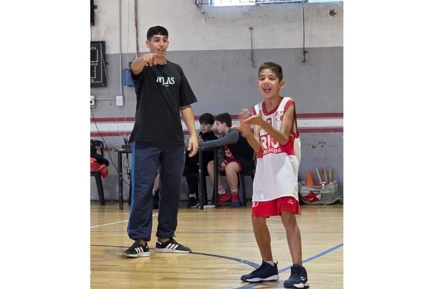 El niño juega al básquet. En la foto, con su "profe". Crédito: Gentileza