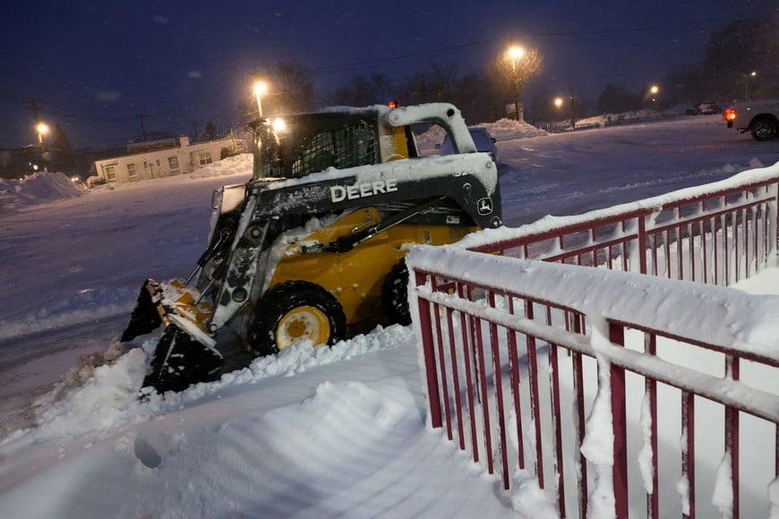 A skid-steer loader clears snow during a winter storm at the Manhasset transportation station in Manhasset, New York, U.S., February 23, 2026. REUTERS/Shannon Stapleton