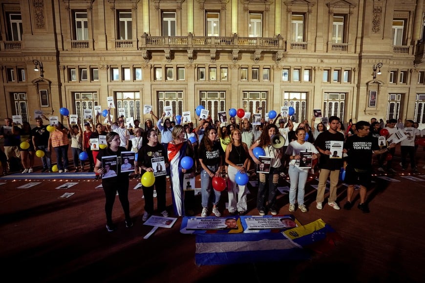 People hold balloons and display signs with portraits, as Venezuelans residing in Argentina and other people gather for a vigil calling for the release of all political prisoners in Venezuela, a month after the U.S. capture of Venezuelan leader Nicolas Maduro and his wife Cilia Flores, in Buenos Aires, Argentina, February 3, 2026. REUTERS/Mariana Nedelcu