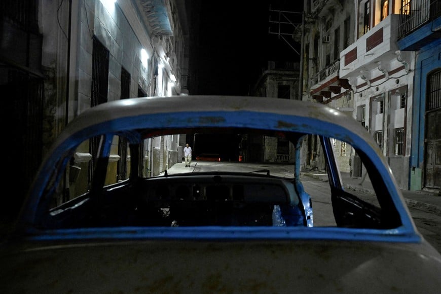 A man walks down a street after power was restored following a partial collapse of the electrical grid that left much of western Cuba in the dark, in Havana, Cuba, December 3, 2025. REUTERS/Norlys Perez TPX IMAGES OF THE DAY