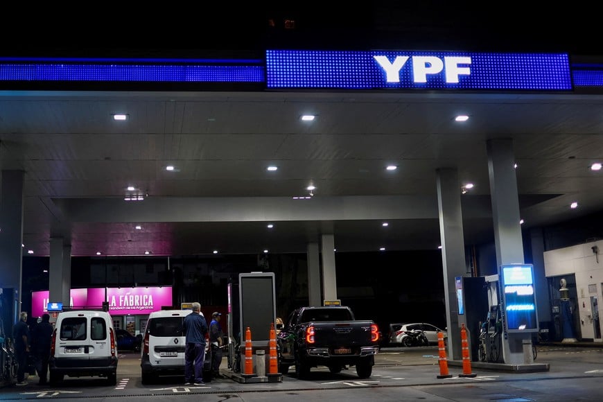 FILE PHOTO: People fuel their vehicles at YPF gas station on the day of a 24-hour general strike against the adjustment policy of Argentinian President Javier Milei's government, in Buenos Aires, Argentina April 10, 2025. REUTERS/Agustin Marcarian/File Photo