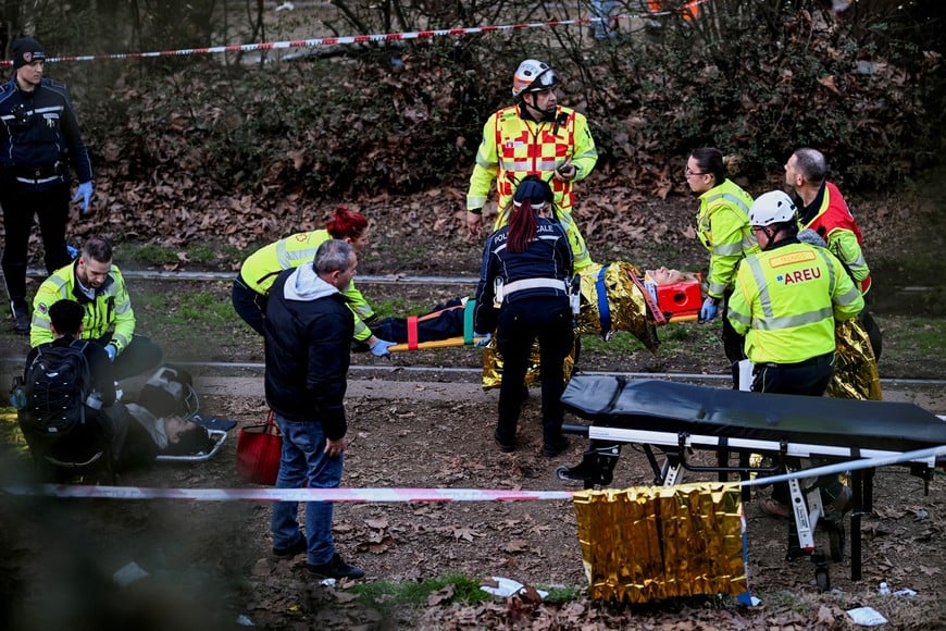 A person receives medical assistance at the scene following a deadly tram derailment in Milan, Italy, February 27, 2026. REUTERS/Daniele Mascolo