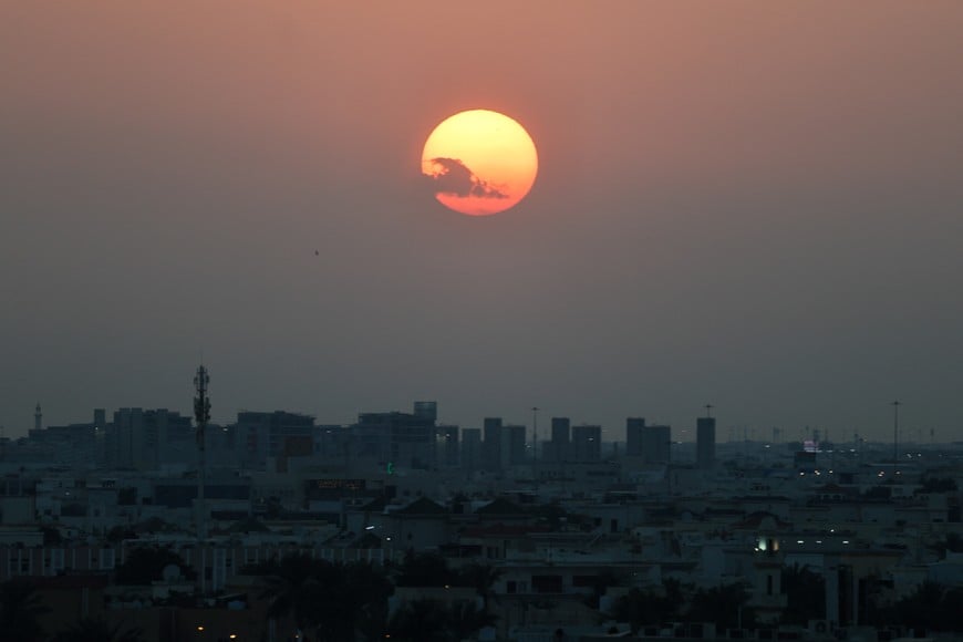 The sun sets over the city skyline, after reported Iranian missile attacks, following strikes by the United States and Israel against Iran, in Doha, Qatar, February 28, 2026. REUTERS/Mohammed Salem