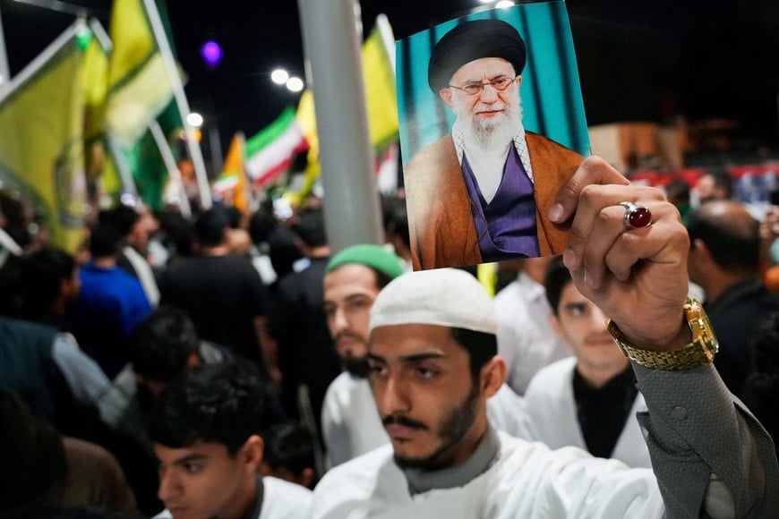 A man displays a portrait of Iran's Supreme Leader Ayatollah Ali Khamenei as supporters of Iraqi Shi'ite armed groups gather to show support for Iran on the day the United States and Israel launched strikes on Iran, in Basra, Iraq, February 28, 2026. REUTERS/ Essam al-Sudani