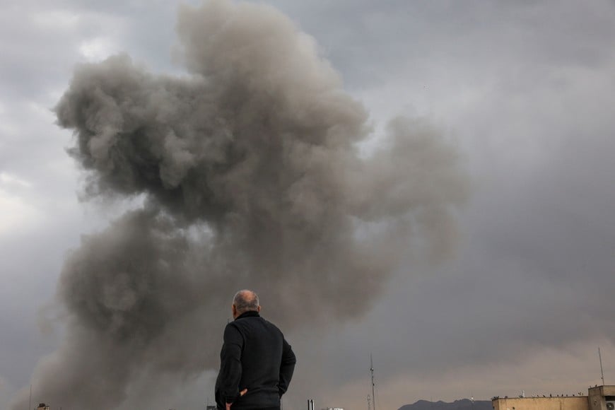 A person looks on as smoke rises following an explosion, after Israel and the U.S. launched strikes on Iran, amid the U.S.-Israel conflict with Iran, in Tehran, Iran, March 2, 2026. Majid Asgaripour/WANA (West Asia News Agency) via REUTERS ATTENTION EDITORS - THIS PICTURE WAS PROVIDED BY A THIRD PARTY     TPX IMAGES OF THE DAY