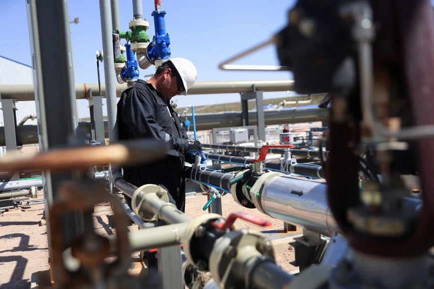 An employee works on pipes near a drilling rig in Vaca Muerta shale oil and gas drilling, in the Patagonian province of Neuquen, Argentina November 3, 2022. REUTERS/Tomas Cuesta NO RESALES. NO ARCHIVES